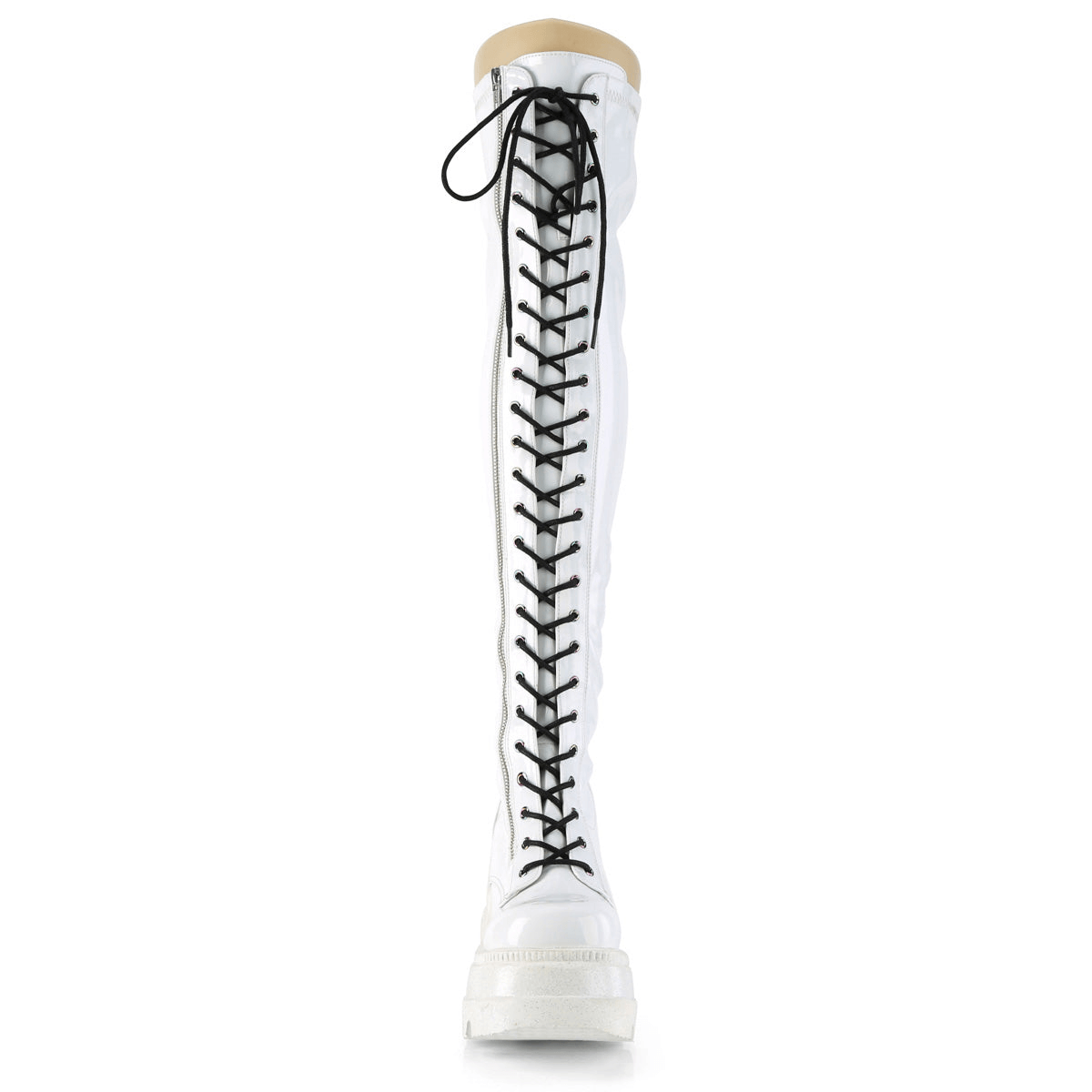 White thigh-high lace-up wedge boots with holographic finish and metal zipper, showcasing a bold fashion statement.