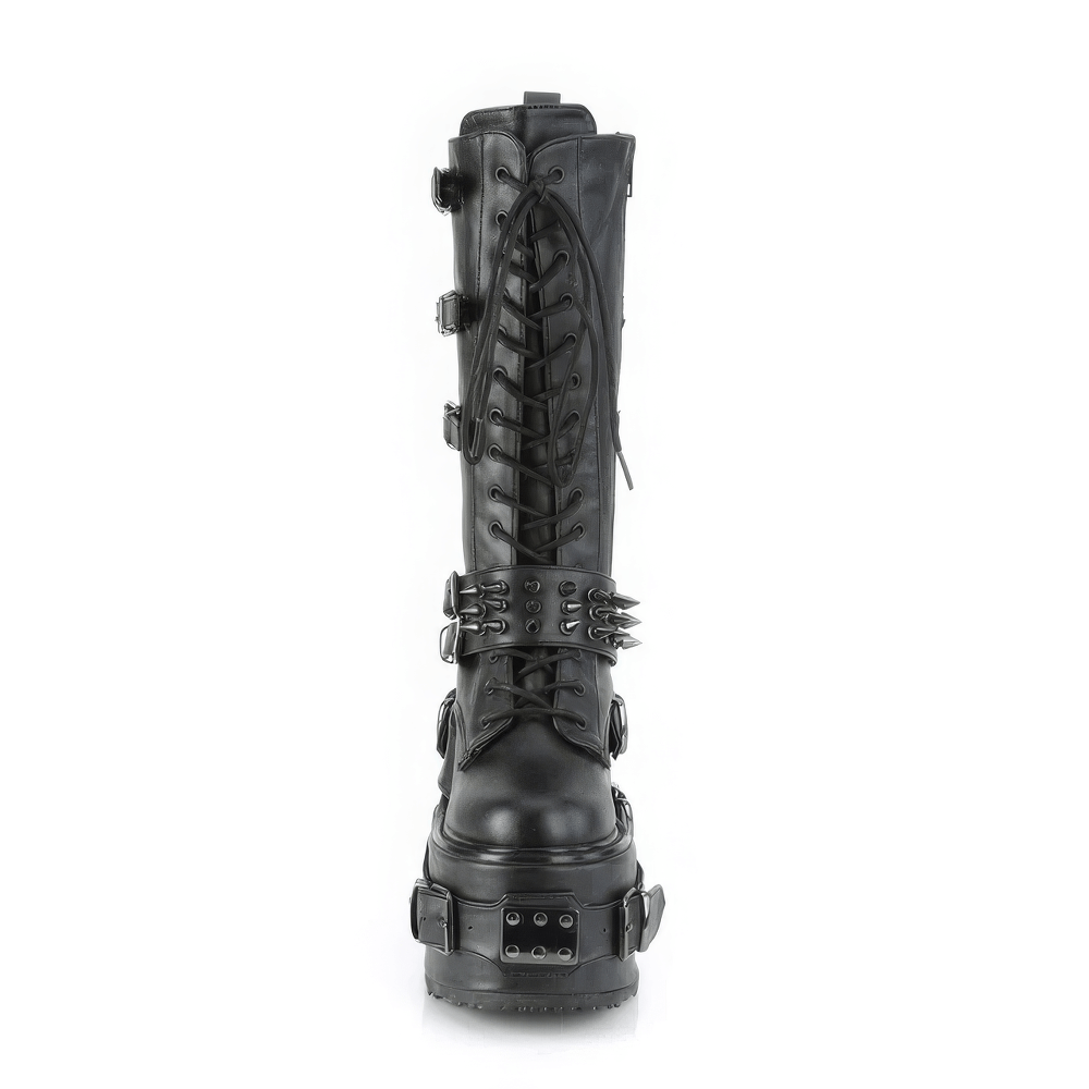 Demonia knee-high platform boots with spiked buckle straps, lace-up design, and metal details for alternative fashion.