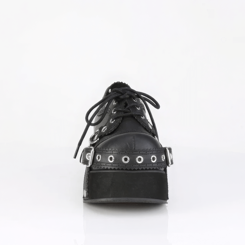 Front view of DEMONIA Lace-Up Platform Shoes with buckle straps and eyelet detailing in black vegan leather.