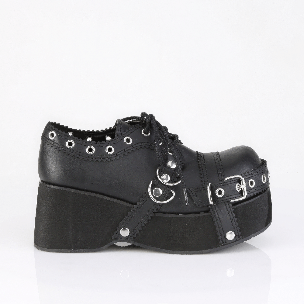 Demonia lace-up platform shoes featuring buckle straps, eyelet details, and scallop trim in black vegan leather.