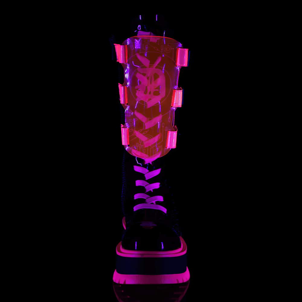 Demonia neon pink platform boots with clear straps, mid-calf lace-up design, and edgy chain details, glowing under UV light.