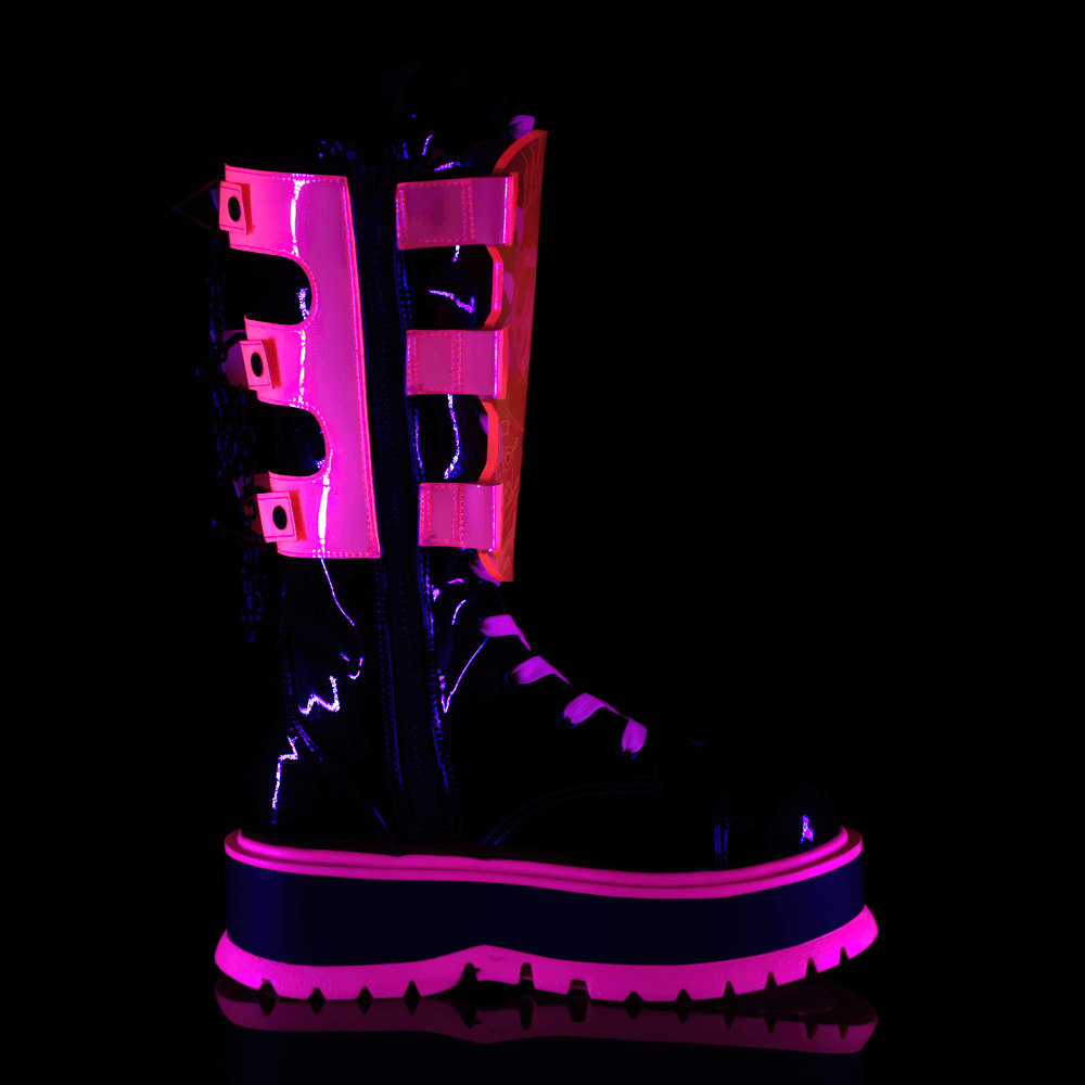 Demonia neon pink platform boots with clear straps, mid-calf lace-up, and edgy chain details, glowing under UV light.
