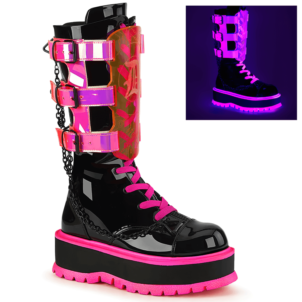 Demonia neon pink platform boots with clear straps, mid-calf lace-up design, UV reactive, and chain details for edgy style.