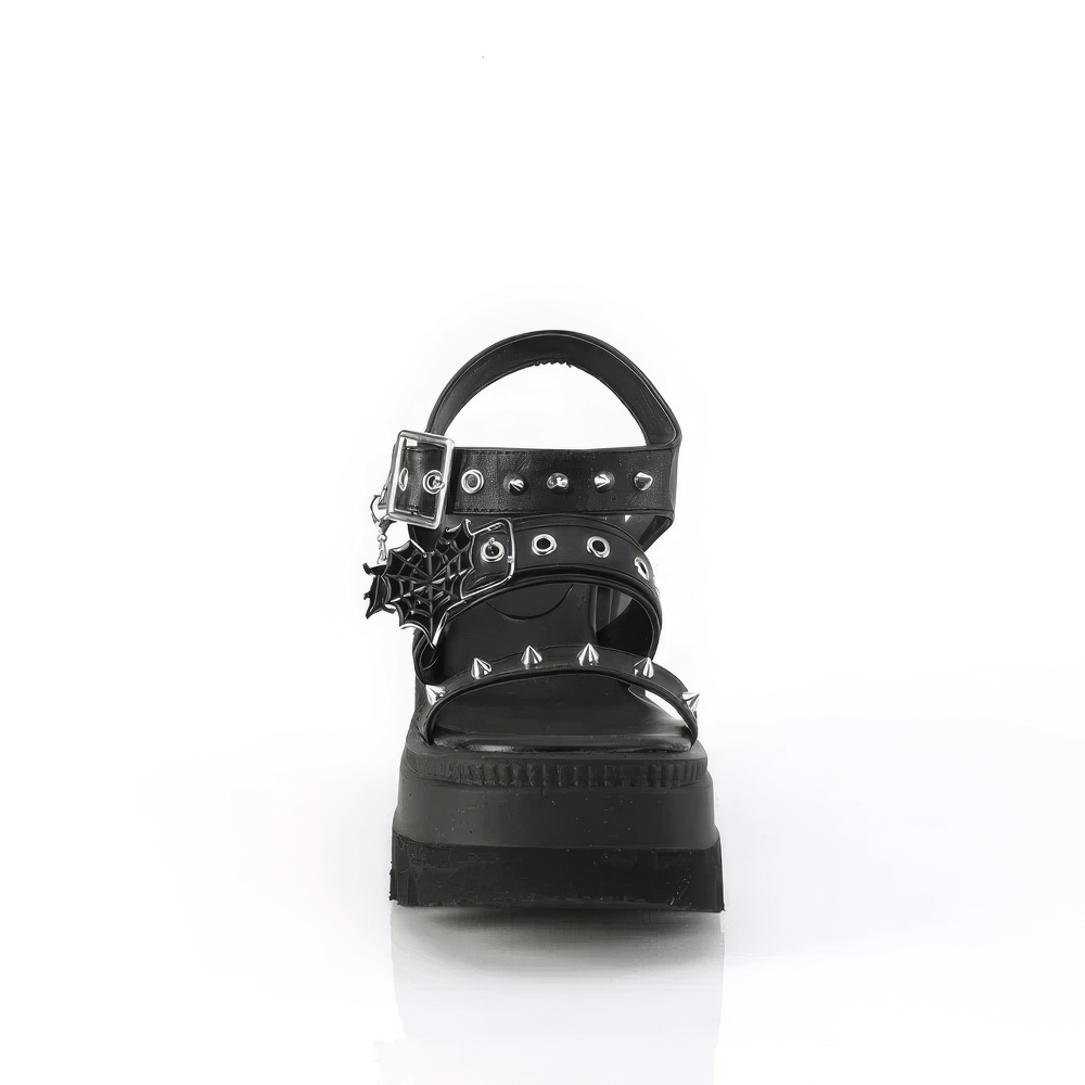 Demonia black platform sandals with studs and heart buckle, featuring bold spikes and charm detail.
