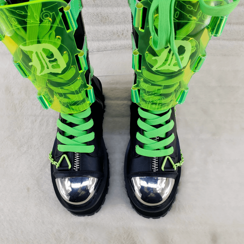 Futuristic mid-calf platform boots with silver toe cap and green UV-reactive straps, perfect for alternative fashion.