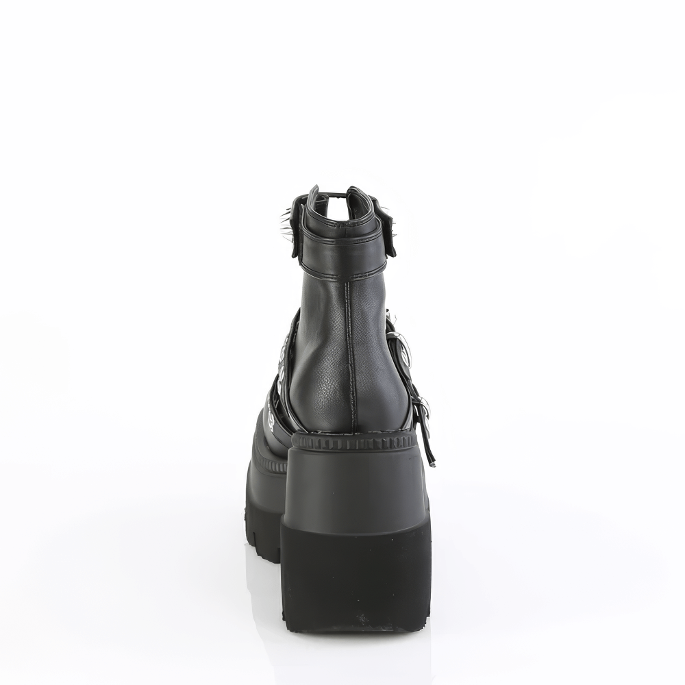 Back view of DEMONIA spike-adorned wedge black platform ankle boots with a cone spike strap and metal zip.