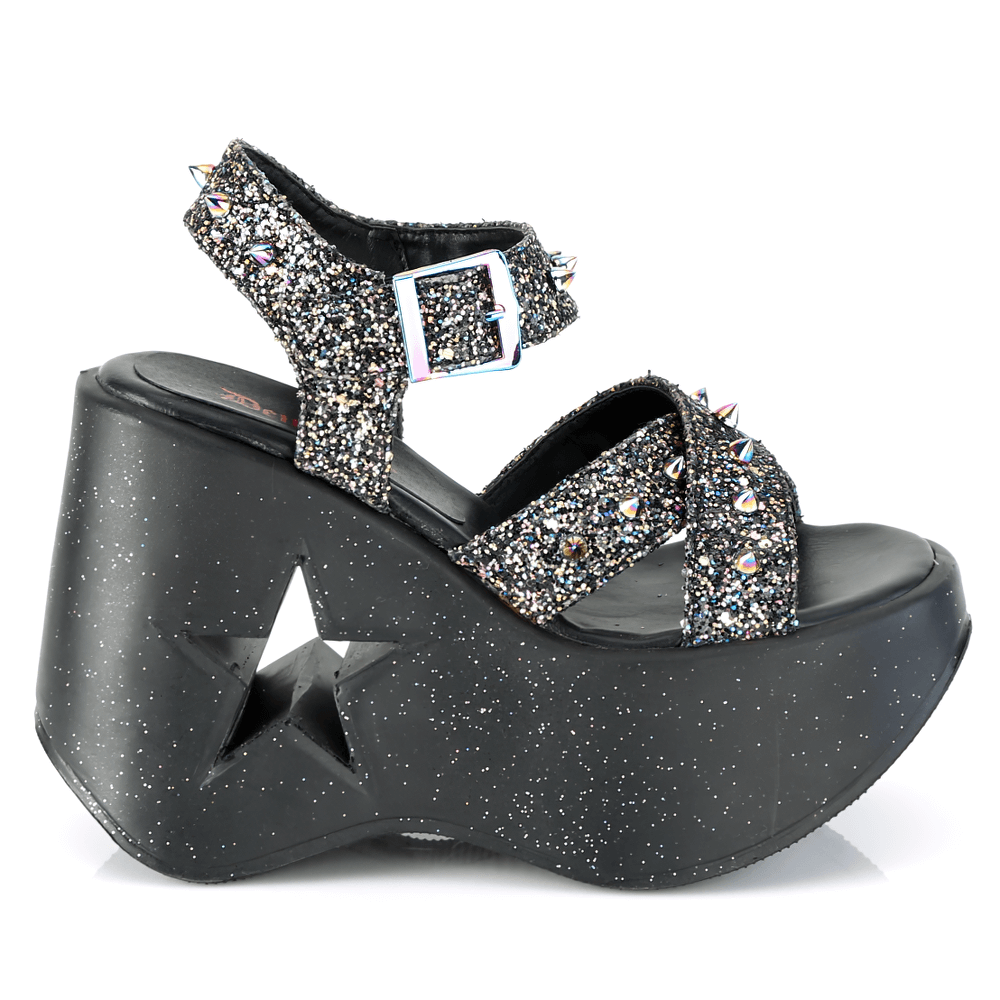 Demonia star cutout glitter wedge sandals with spikes, featuring shimmering black glitter and criss-cross ankle straps.
