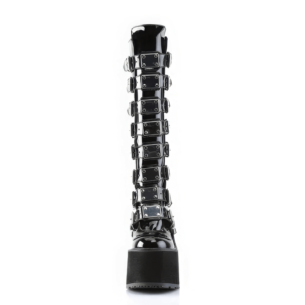 Daring black knee-high platform boots featuring metal buckles and a chic wedge design, perfect for bold fashion statements.
