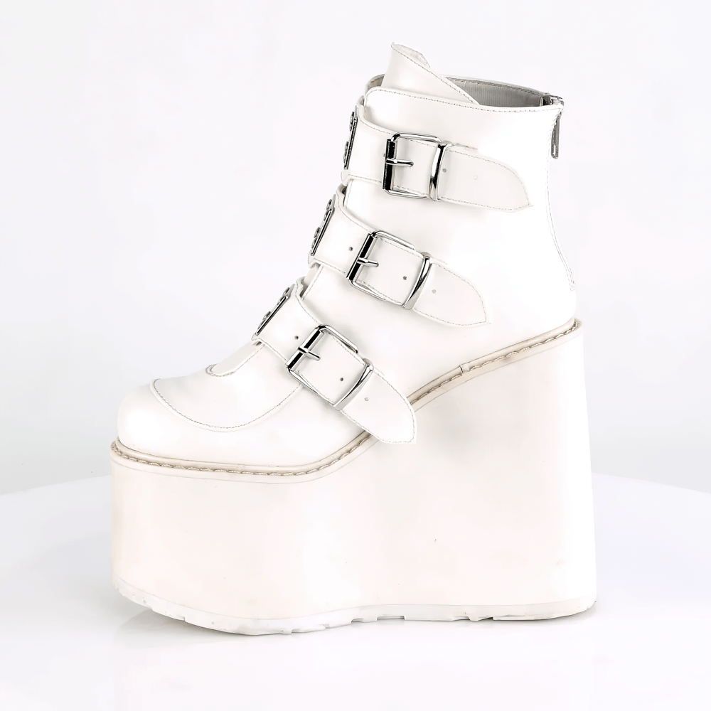 Demonia white wedge platform ankle boots featuring triple buckle straps and a 5 1/2-inch wedge heel.