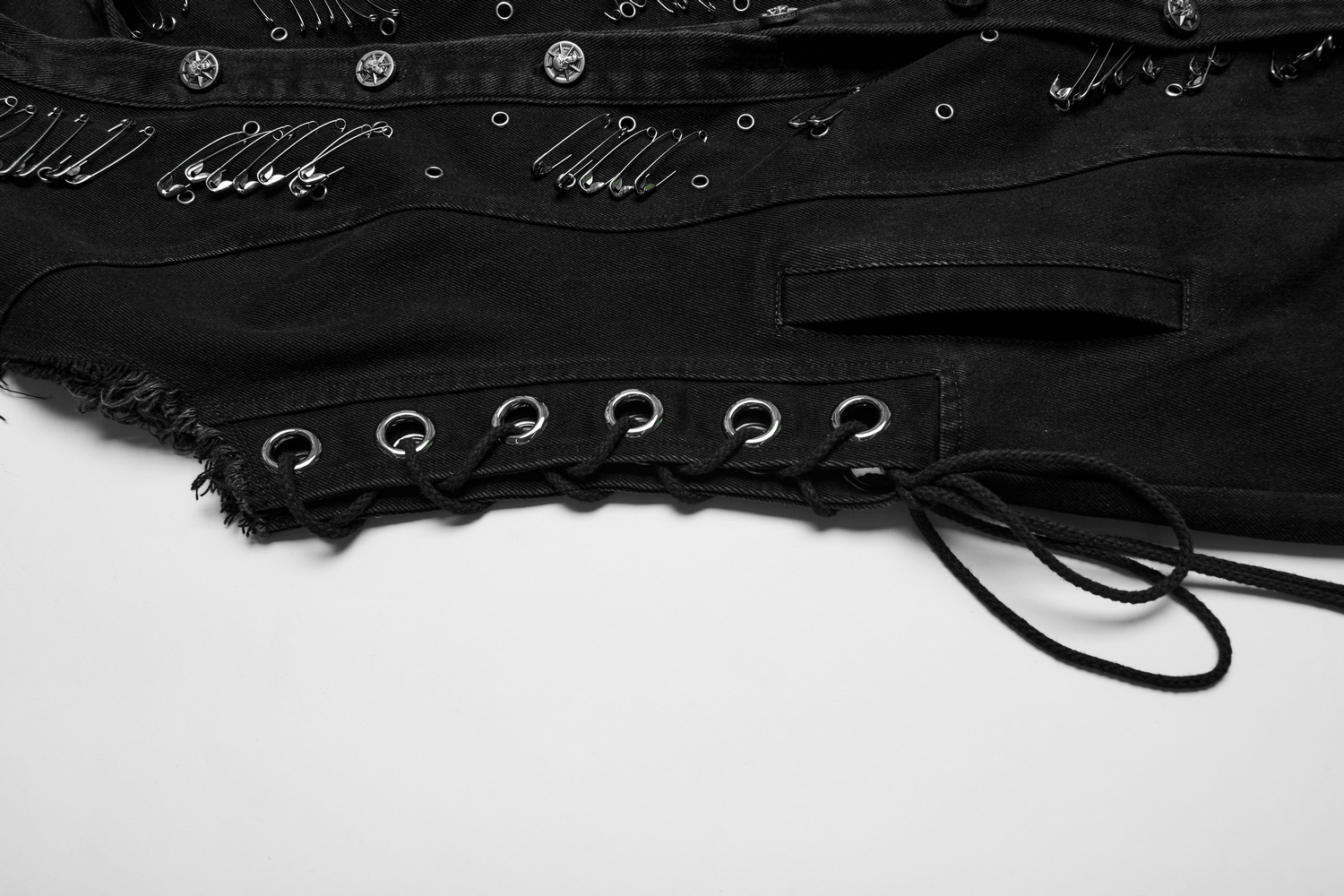 Detailed view of a black denim hooded cape showcasing punk safety pins and raw edge finishes.