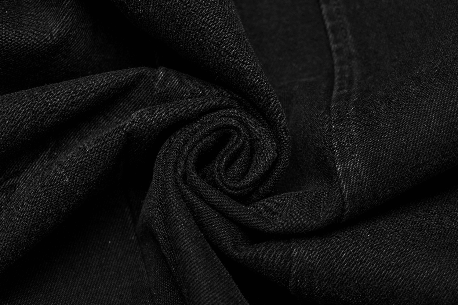 Close-up of black denim fabric, showcasing its soft texture and durable quality for punk-inspired apparel.
