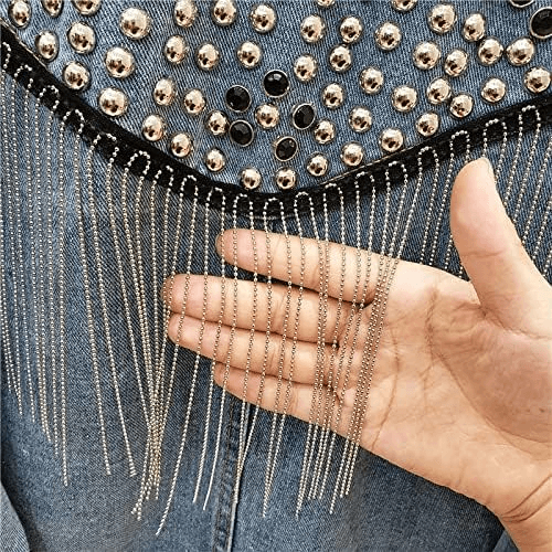 Close-up of decorative tassel fringe and rivets on a women's denim jacket, highlighting stylish details for casual wear.