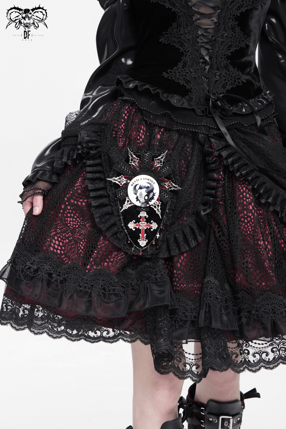 Gothic fashion outfit featuring a black and red lace skirt with skull and cross emblem accents.