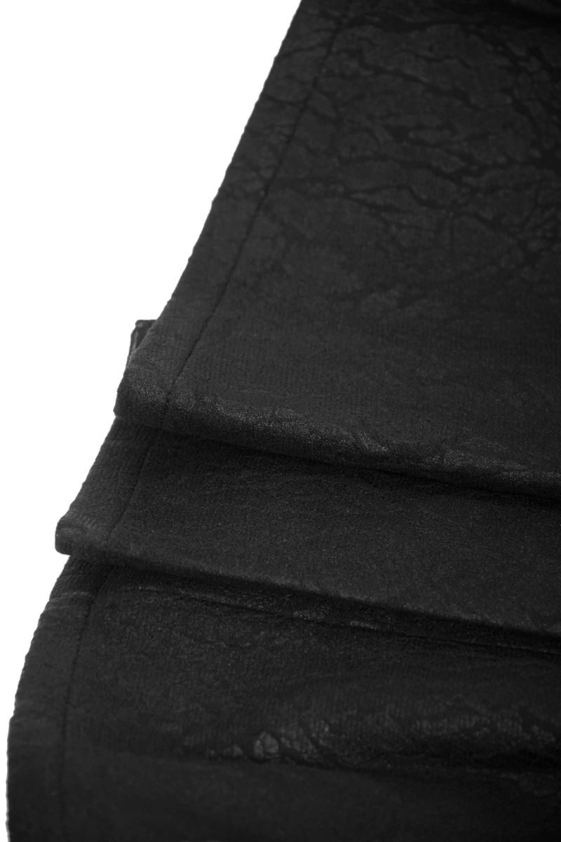 Close-up of the textured fabric of a black asymmetric kilt skirt with folds, showcasing its gothic style.