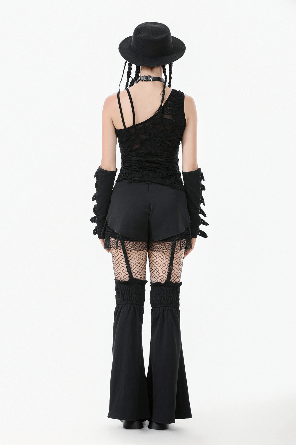 Back view of a model in a distressed asymmetrical gothic top, punk gloves, and flared pants, styled with a black hat.