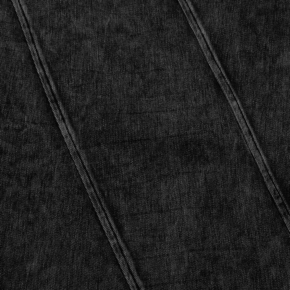 Close-up of distressed black denim fabric showcasing slashed stitch design for punk-inspired tank tops.