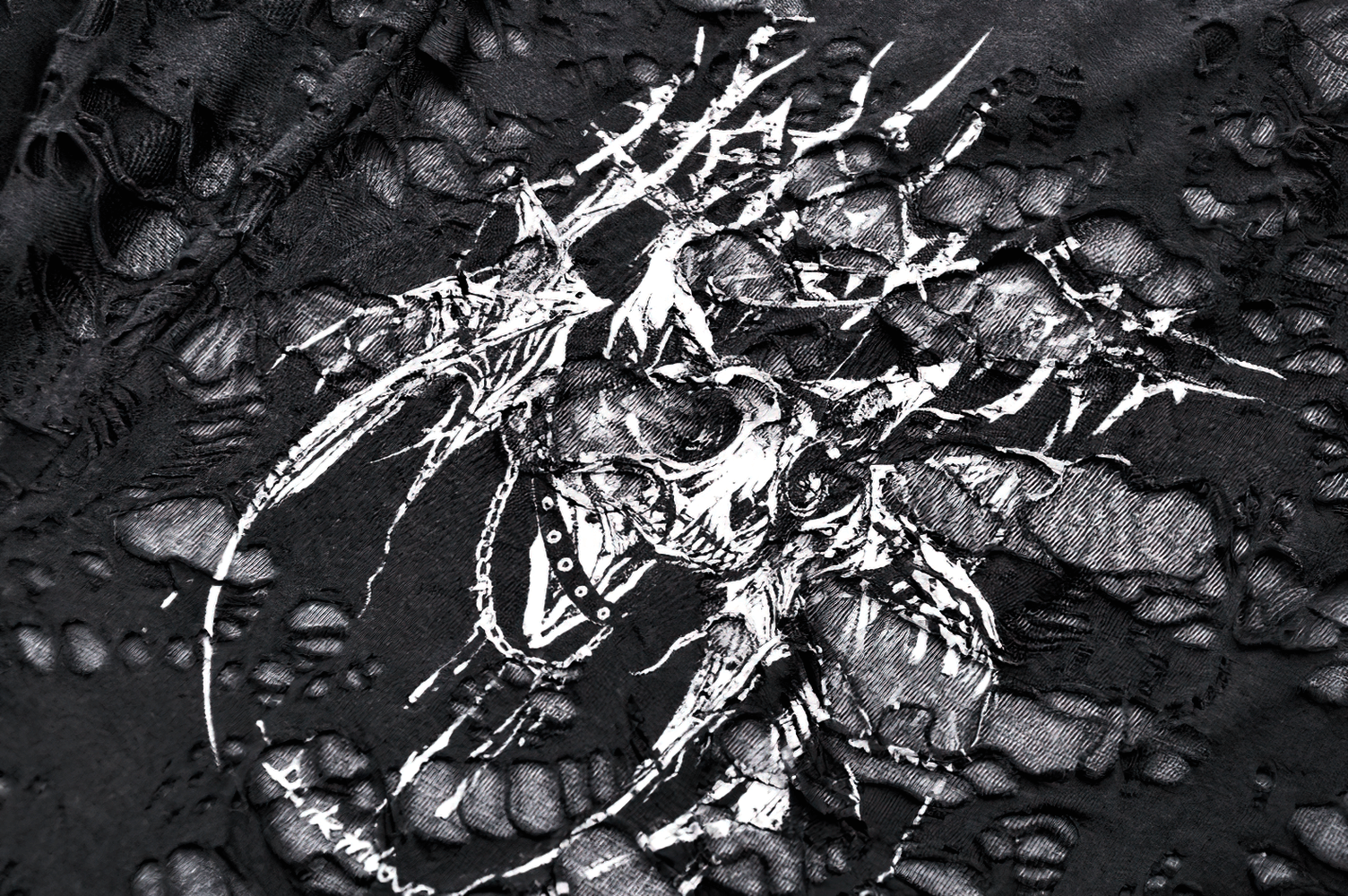 Close-up of a distressed black punk tank top featuring a skull graphic and ripped net design.