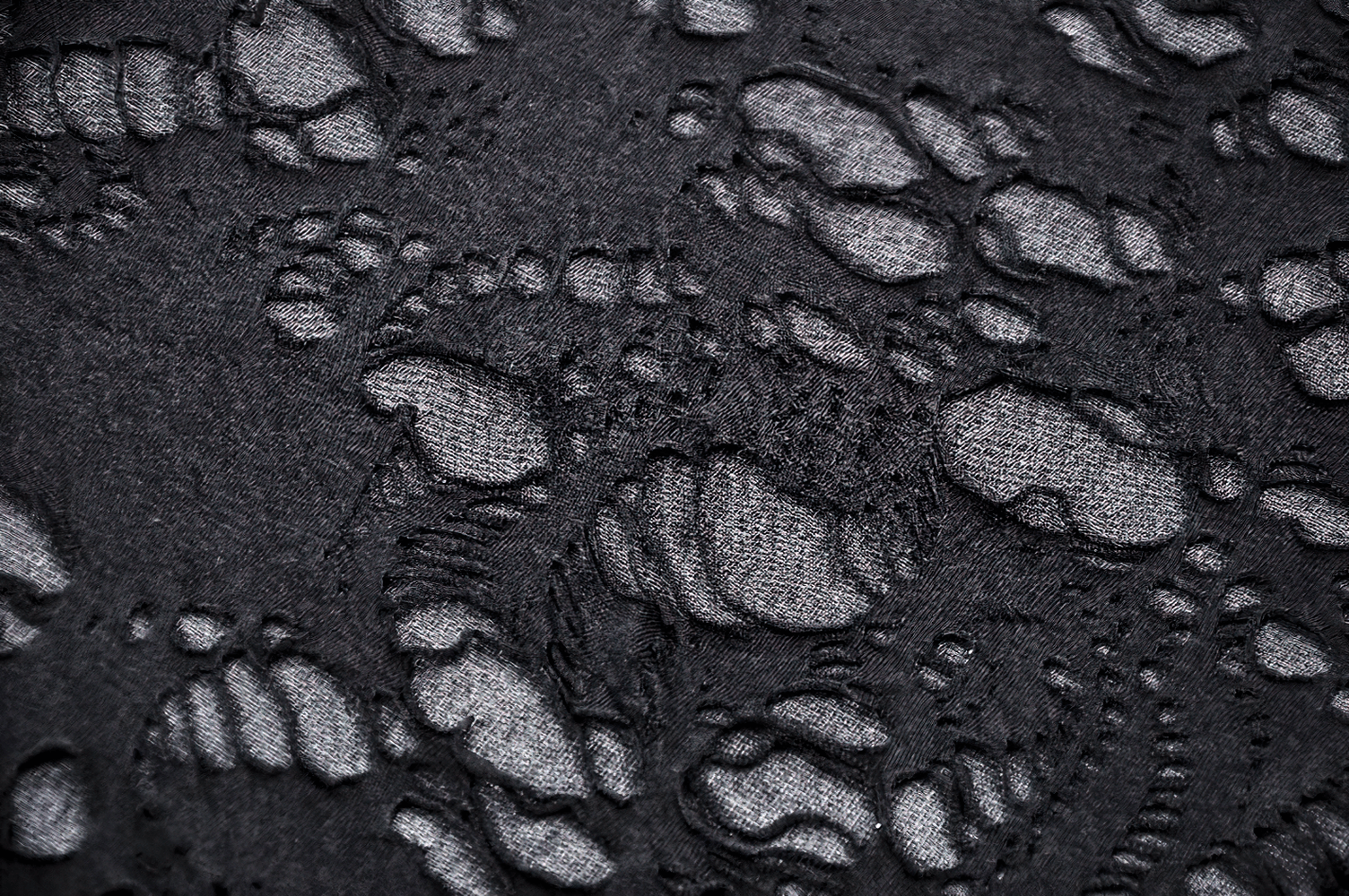 Close-up of distressed black fabric with shredded net design, showcasing the punk and gothic style.
