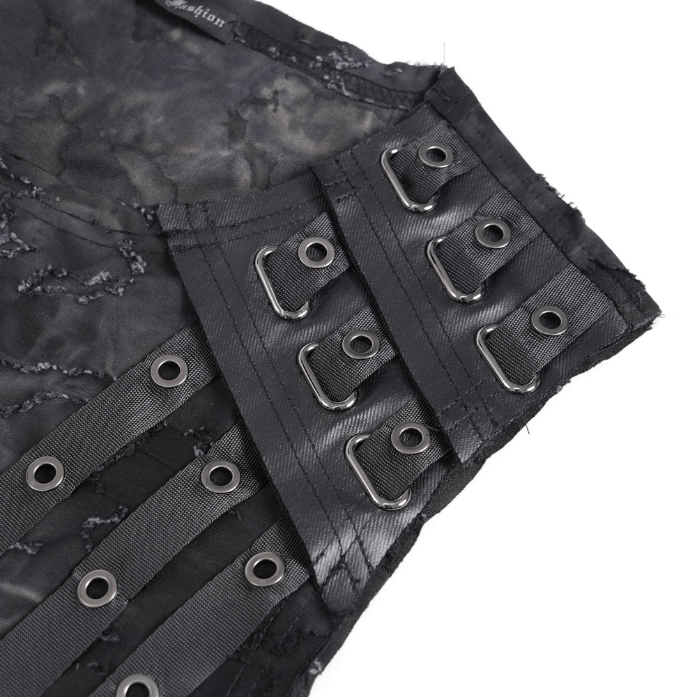 Close-up of distressed black sleeveless top showcasing eyelet strap details and edgy fabric texture.