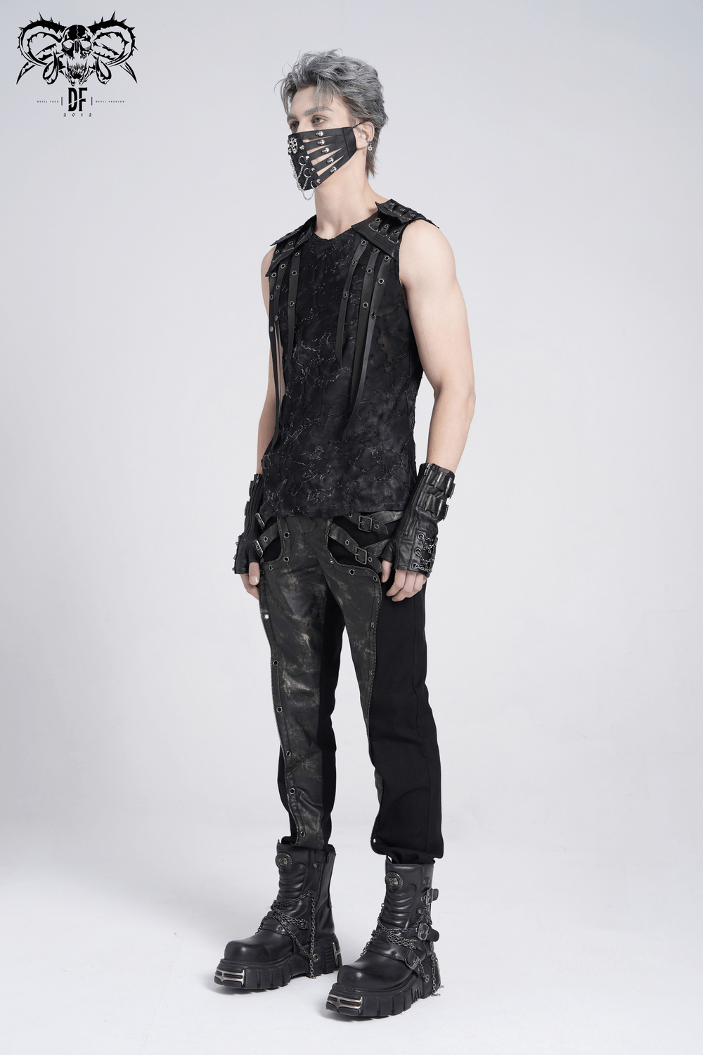 Distressed black sleeveless top with eyelet straps, showcased with edgy black pants and boots, perfect for a bold style.