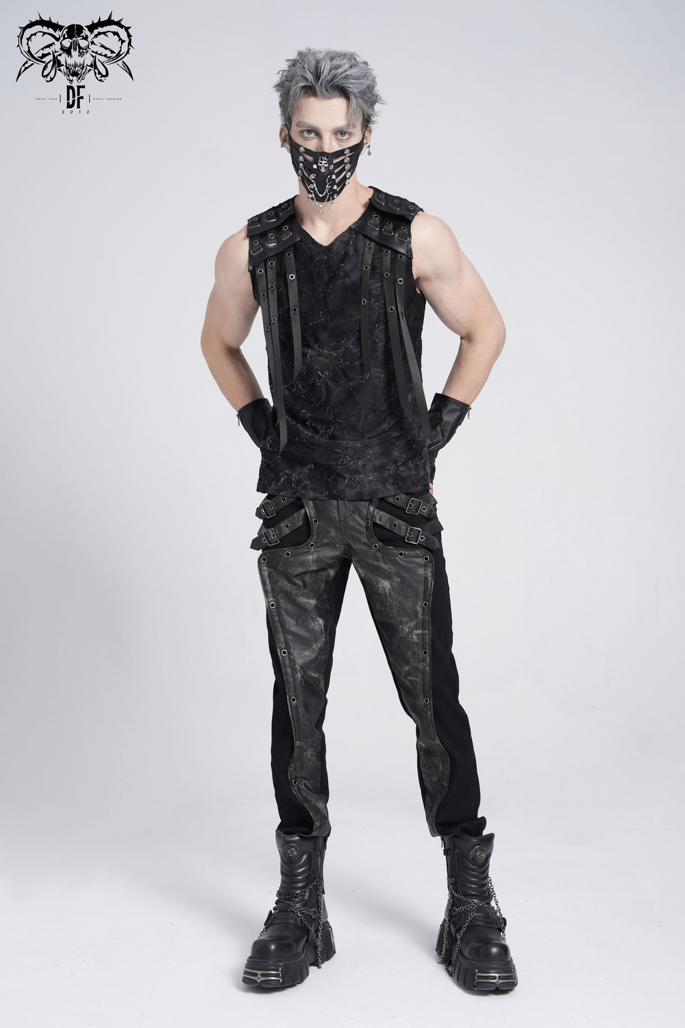 Stylish model showcasing a distressed black sleeveless top with eyelet straps and edgy accessories.