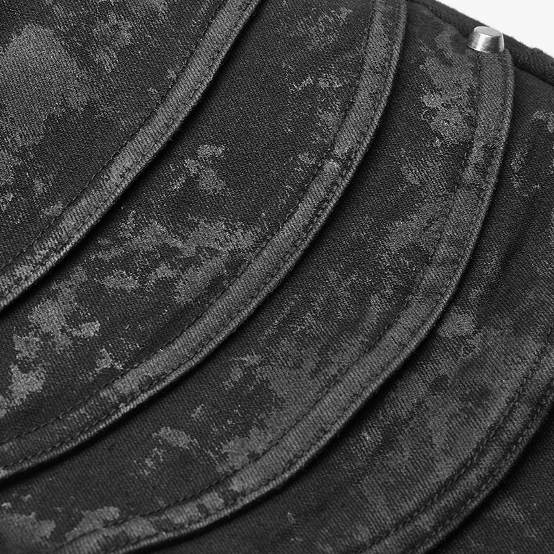 Close-up of distressed denim jeans featuring unique layered knee armor detail with a rugged, edgy look.