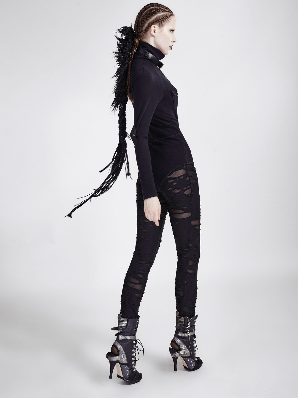 Bold woman in distressed gothic mesh-panel leggings, showcasing edgy fashion and rebellious style.