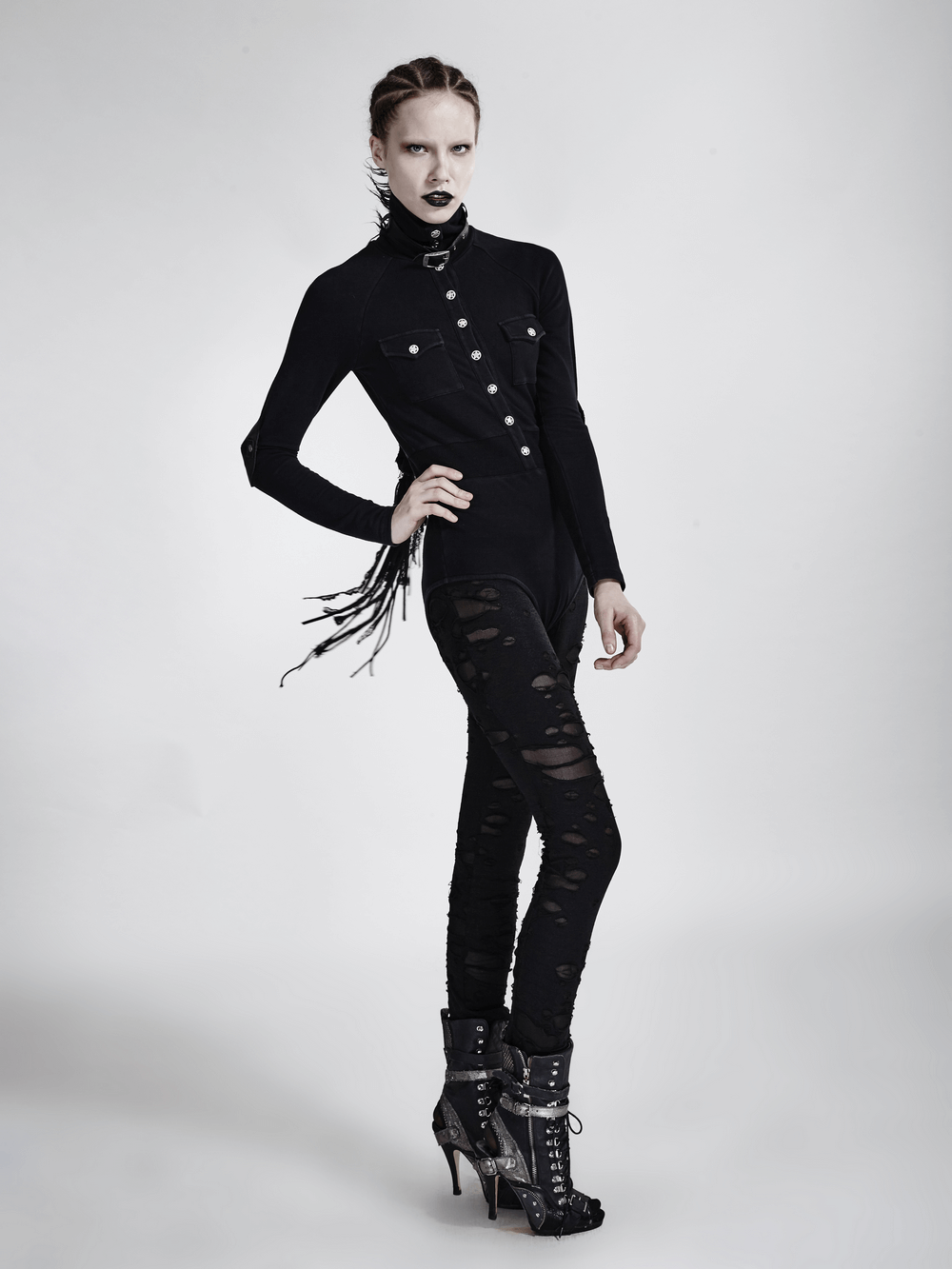 Woman in distressed gothic mesh-panel leggings and a fitted top, showcasing punk fashion style.