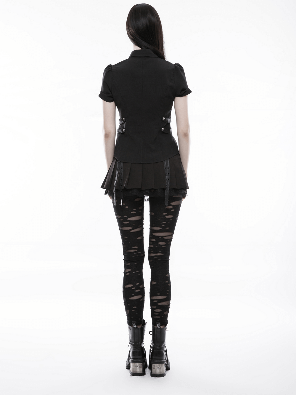 Woman wearing distressed gothic mesh-panel leggings and stylish black top, showcasing punk fashion aesthetics.