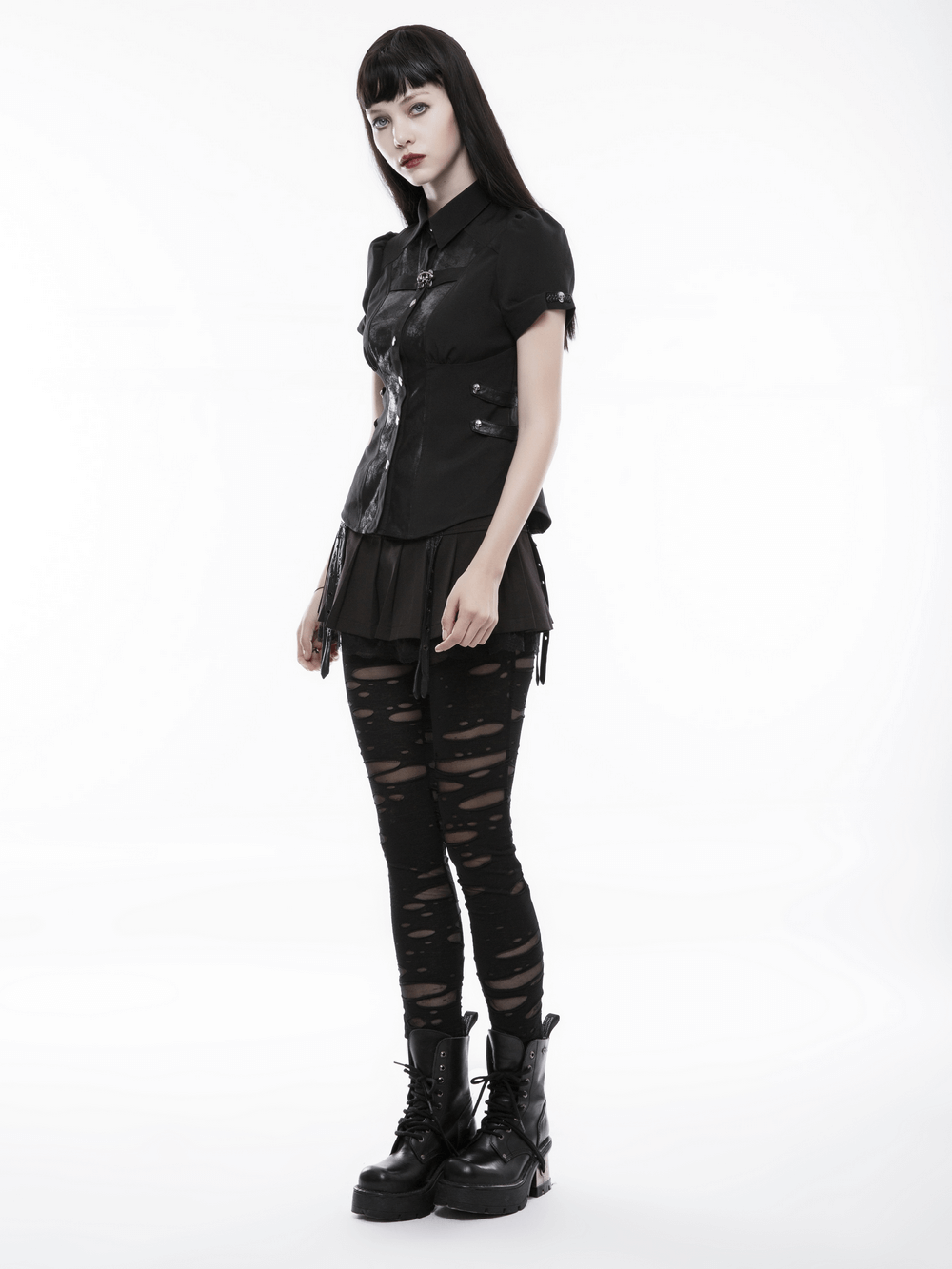 Woman in distressed gothic mesh-panel leggings and black outfit, showcasing punk rave style with bold shredded details.