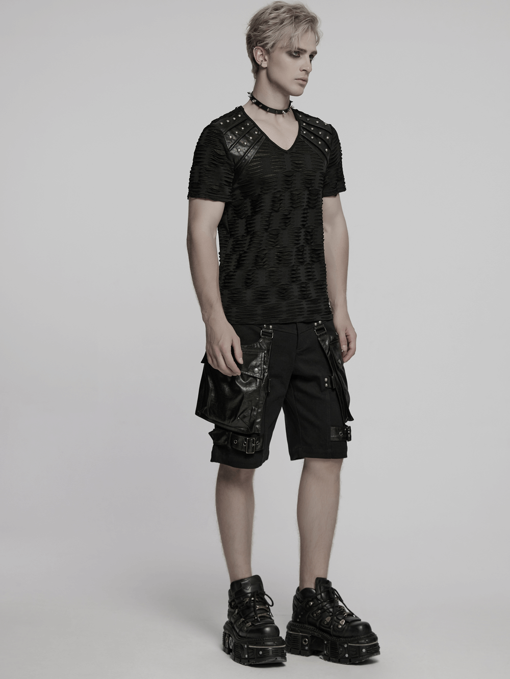Man showcasing a Distressed Gothic T-Shirt with rivet shoulder detail, styled for punk fashion lovers.