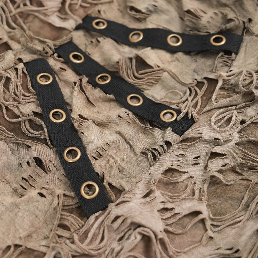 Close-up of distressed fabric with shredded layers and eyelet detailing for an edgy, alternative fashion style.