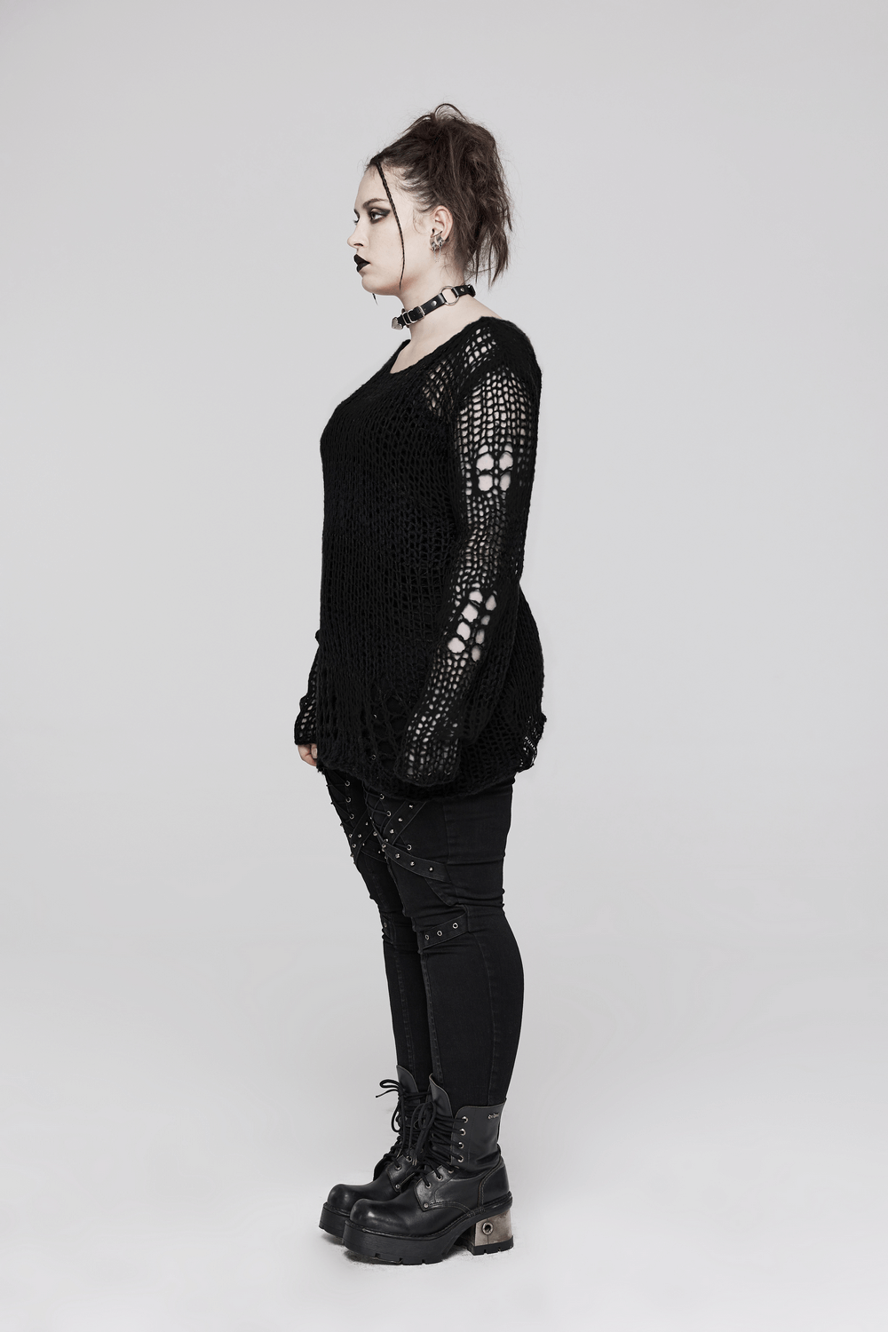 Side view of a model wearing a distressed mohair pullover sweater with holes and edgy style.
