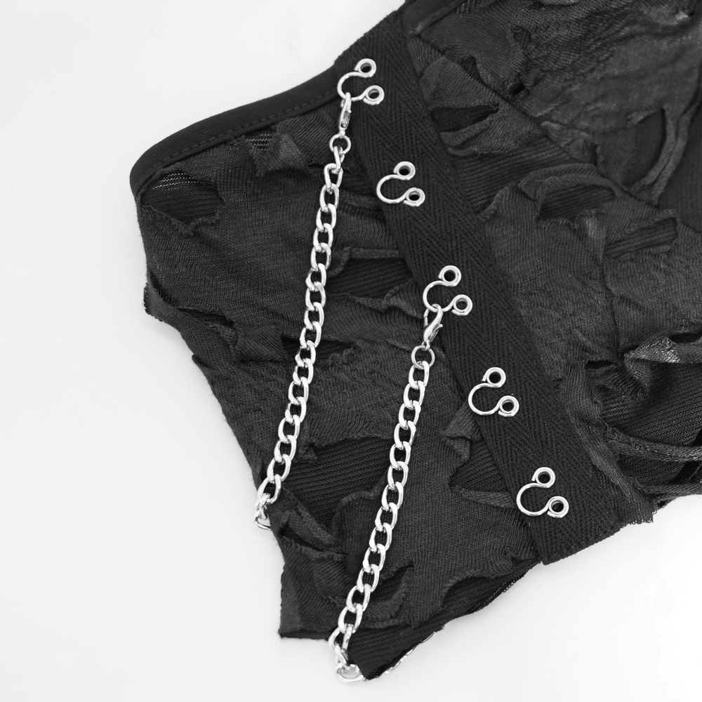Close-up of distressed off-shoulder top with chain and zipper details for a punk-inspired look.