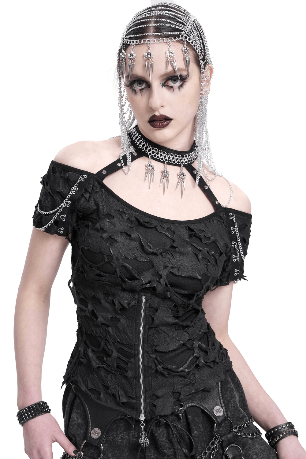 Distressed off-shoulder top featuring chains, zipper detail, and gothic punk aesthetics, styled with edgy accessories.