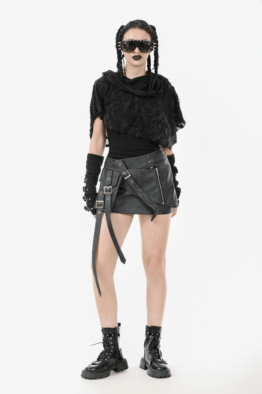 Stylish woman in a distressed punk hooded poncho cape, showcasing a tattered design with edgy accessories.