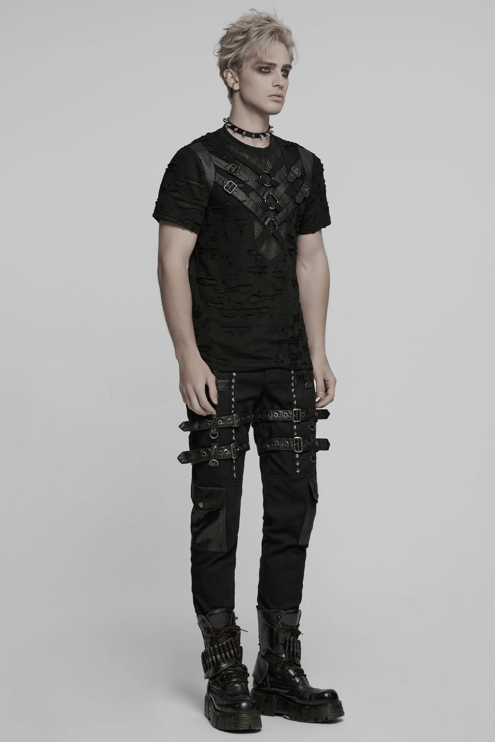 Distressed punk mesh t-shirt with leather straps and rings modelled in edgy streetwear style.