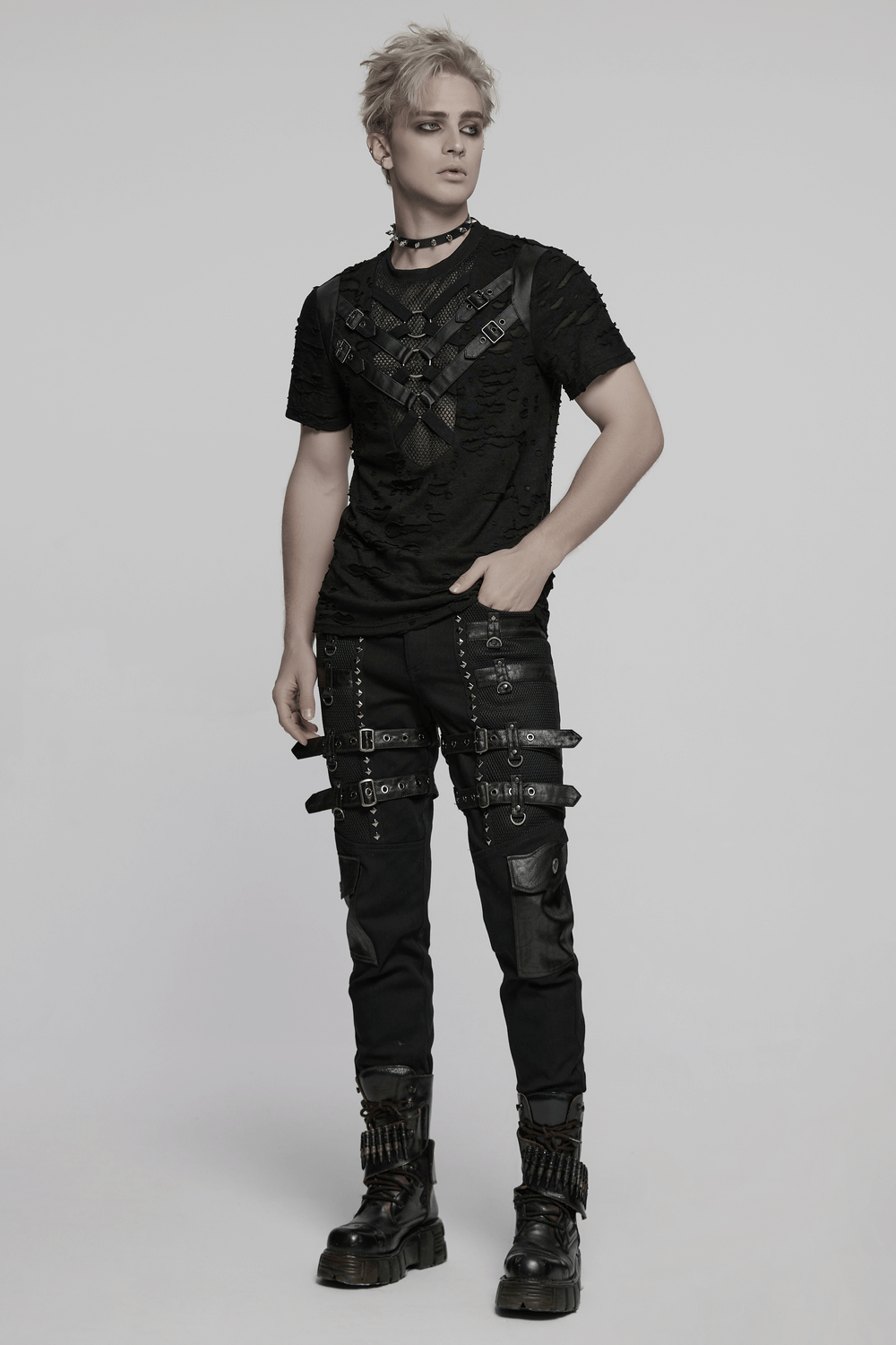 Edgy distressed punk mesh t-shirt with leather straps and rings, styled with bold fashion accessories.