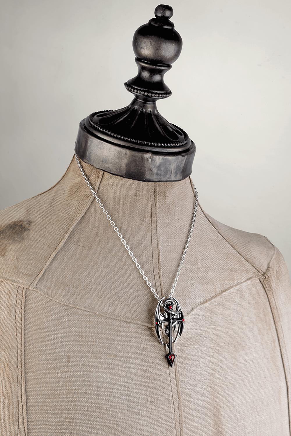Dramatic Draconkreuz pendant with red crystals on a mannequin, showcasing gothic and mystical jewelry design.