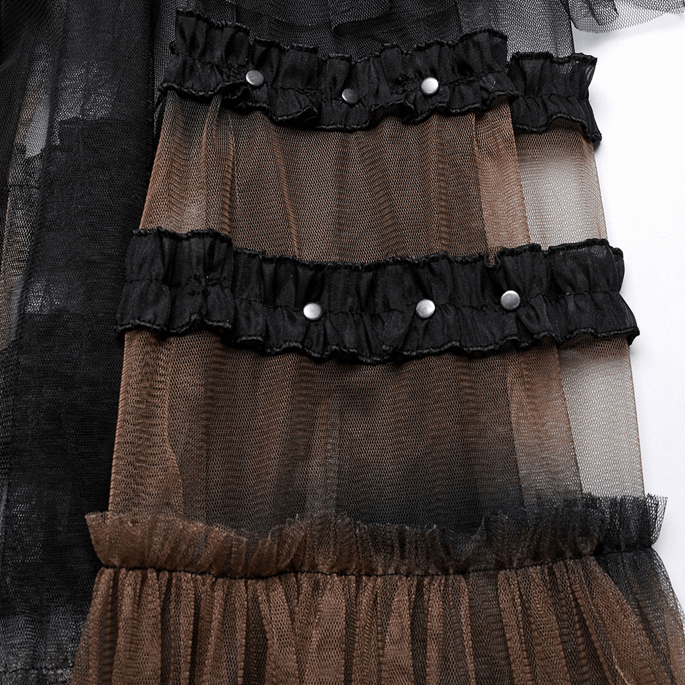 Close-up of layered mesh fabric in black and brown with ruffled edges and decorative buttons, showcasing dramatic style.