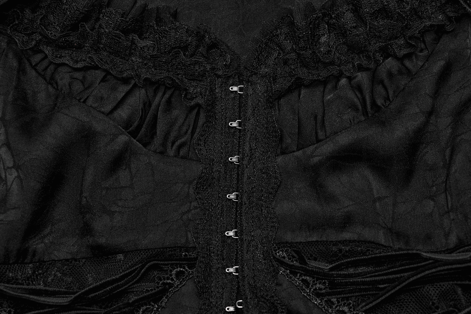Close-up of a black lace blouse showcasing intricate detailing and a dramatic back zipper design for Gothic elegance.