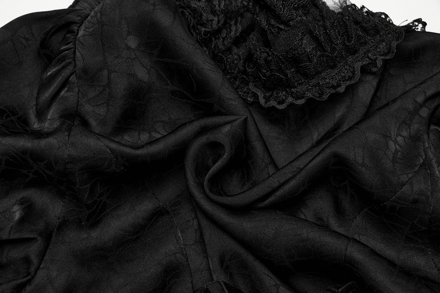 Textured black lace fabric with elegant ruffles, perfect for a gothic blouse or dark fashion statement.