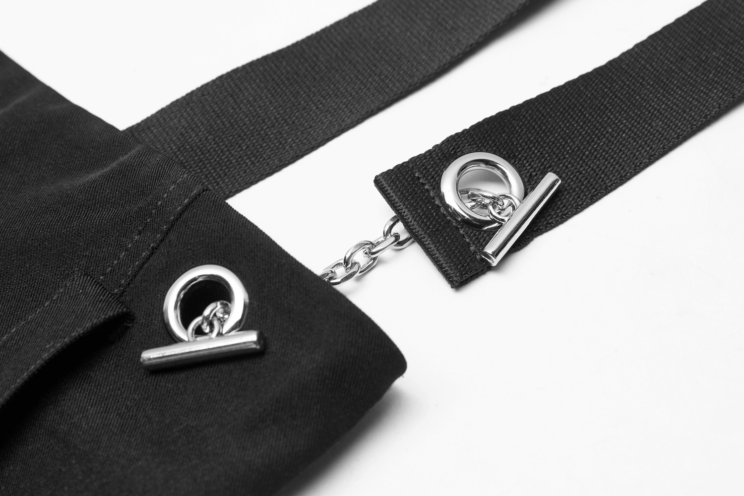 Close-up of detachable chain straps on edgy A-line mini skirt, showcasing unique metal details.