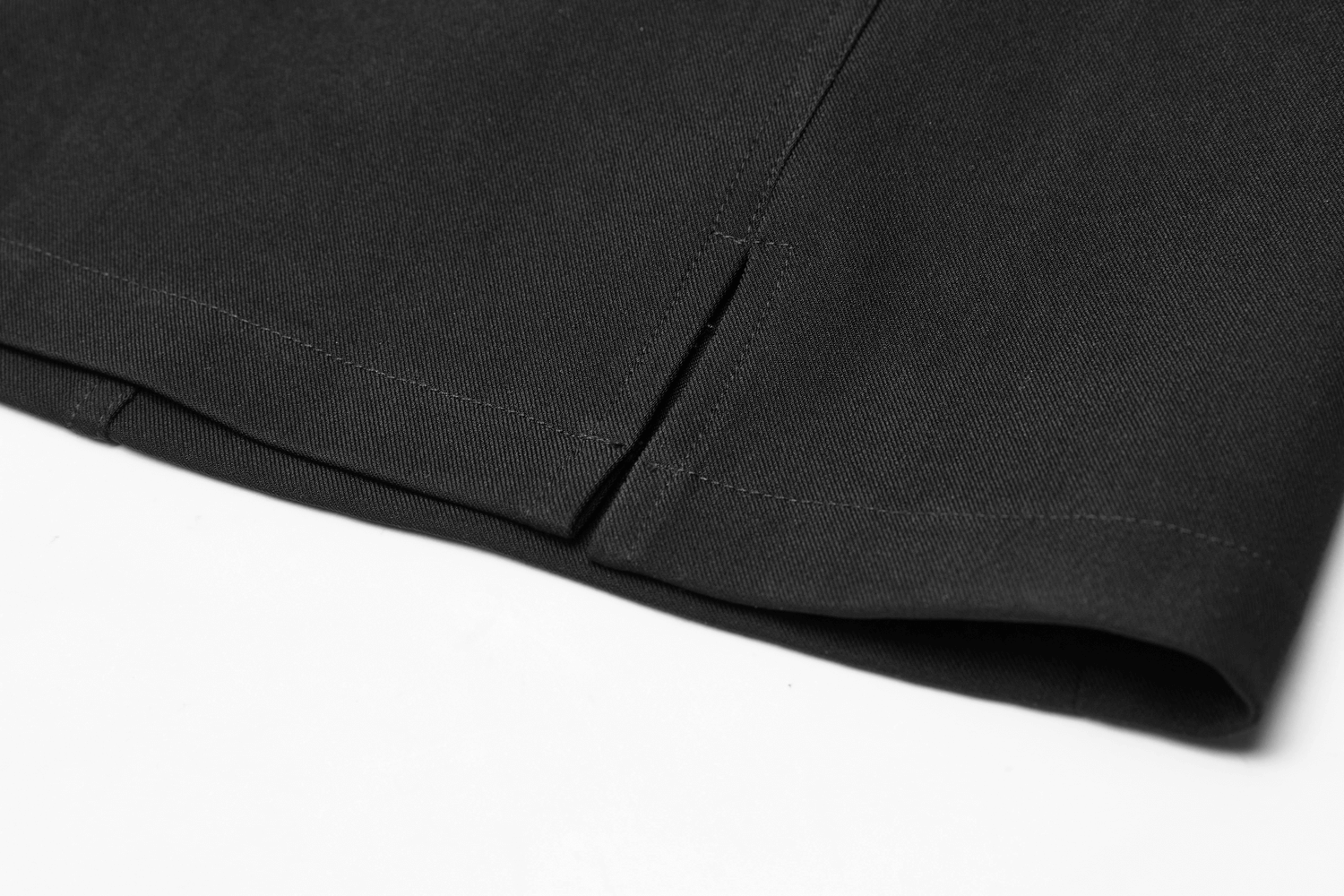 Close-up of the hem and side detail of an edgy A-line mini skirt with chain straps.