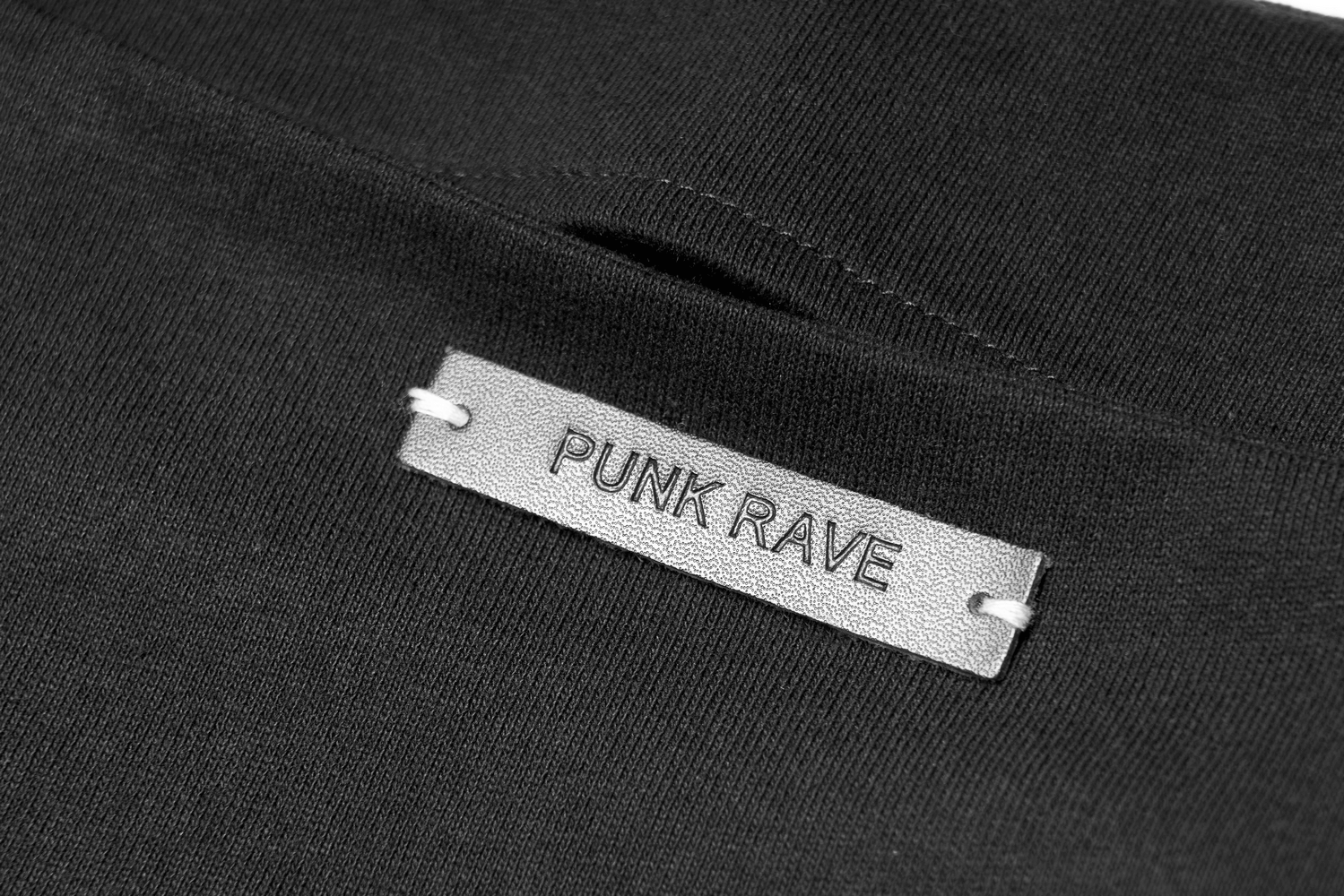 Close-up of PUNK RAVE label on black fabric, showcasing edgy fashion design details.