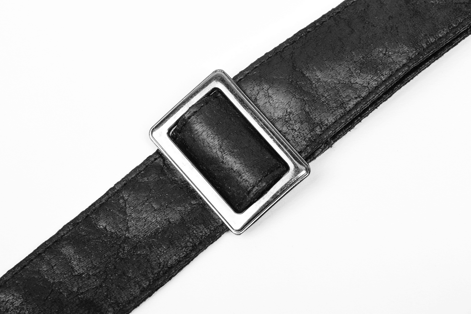 Close-up of a black leather strap with a silver rectangular buckle, perfect for stylish accessories.