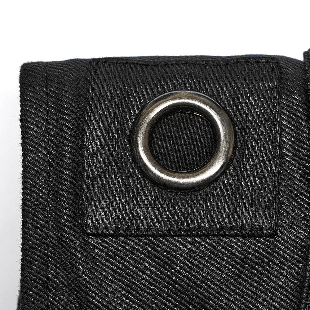 Close-up of a black twill fabric with a metal grommet, showcasing edgy punk vest details for a bold style.