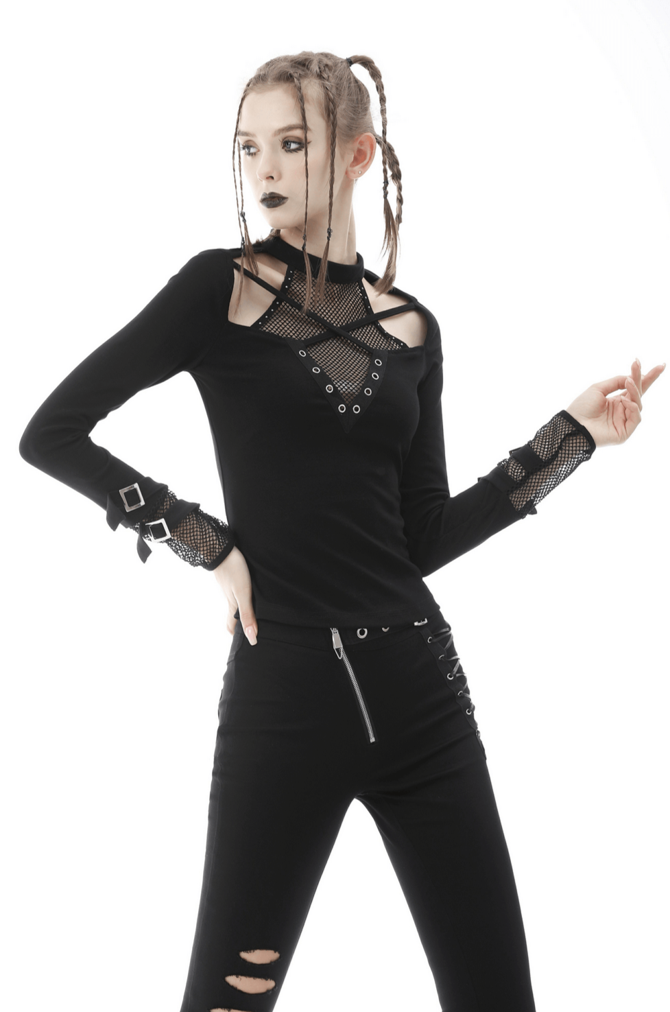 Edgy black cut-out mesh-panel top with studs, styled with skinny pants for a gothic-inspired look.