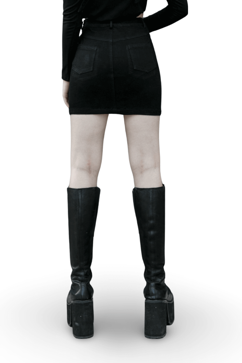 Back view of edgy black denim mini skirt paired with knee-high platform boots, showcasing punk fashion style.