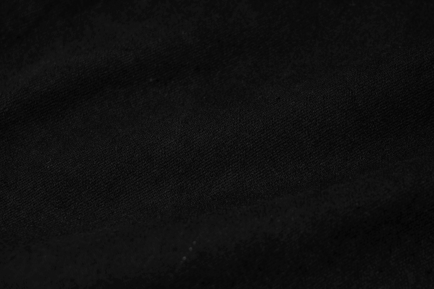 Close-up of textured black denim fabric, showcasing its edgy punk vibe for fashion-forward styles.